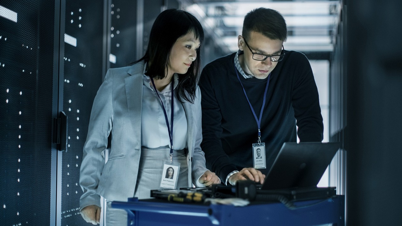 male and female colleagues working on a computer in a cyber stack