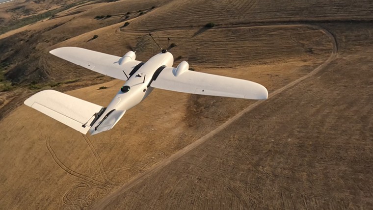 drone flying over a brown field