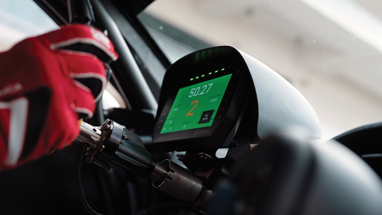 man driving race car with speedometer visible