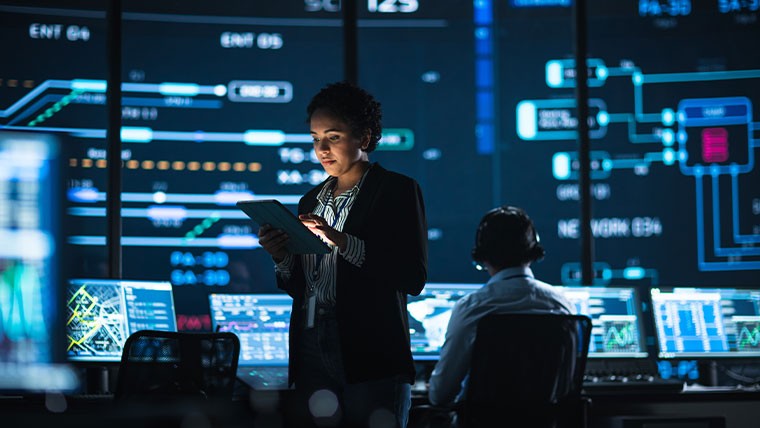 Woman in suit overseeing cyber operations room