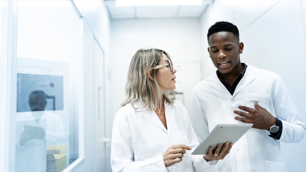 Female and male doctor discuss medical data on ipad