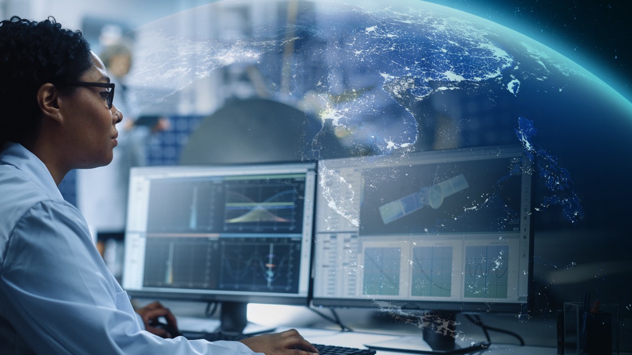 scientist working at computer in front of globe